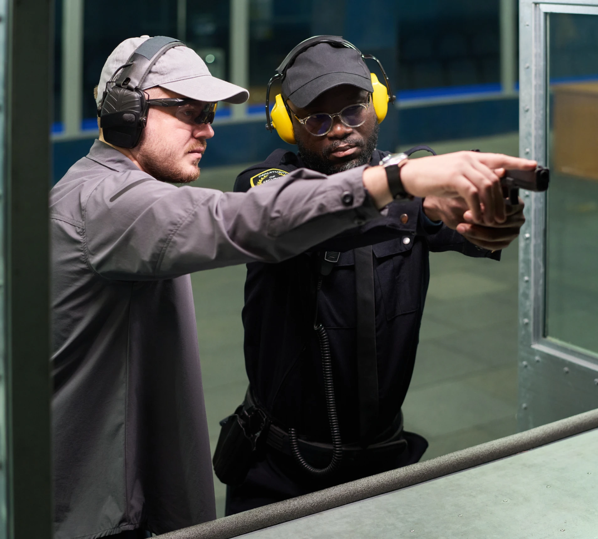 Two men at indoor shooting range.