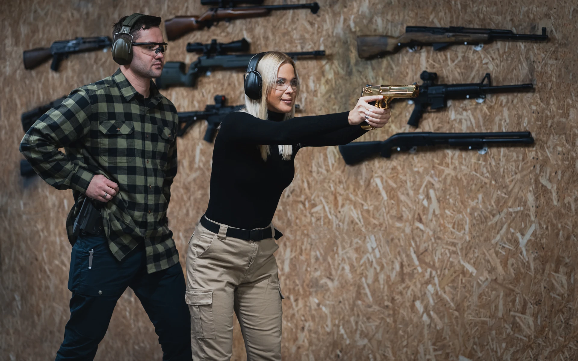 Man instructing woman at shooting range.
